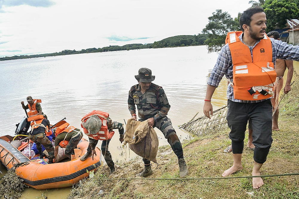 | Photo: PTI : Tripura Floods: Security personnel bring food supplies for distribution at relief camps